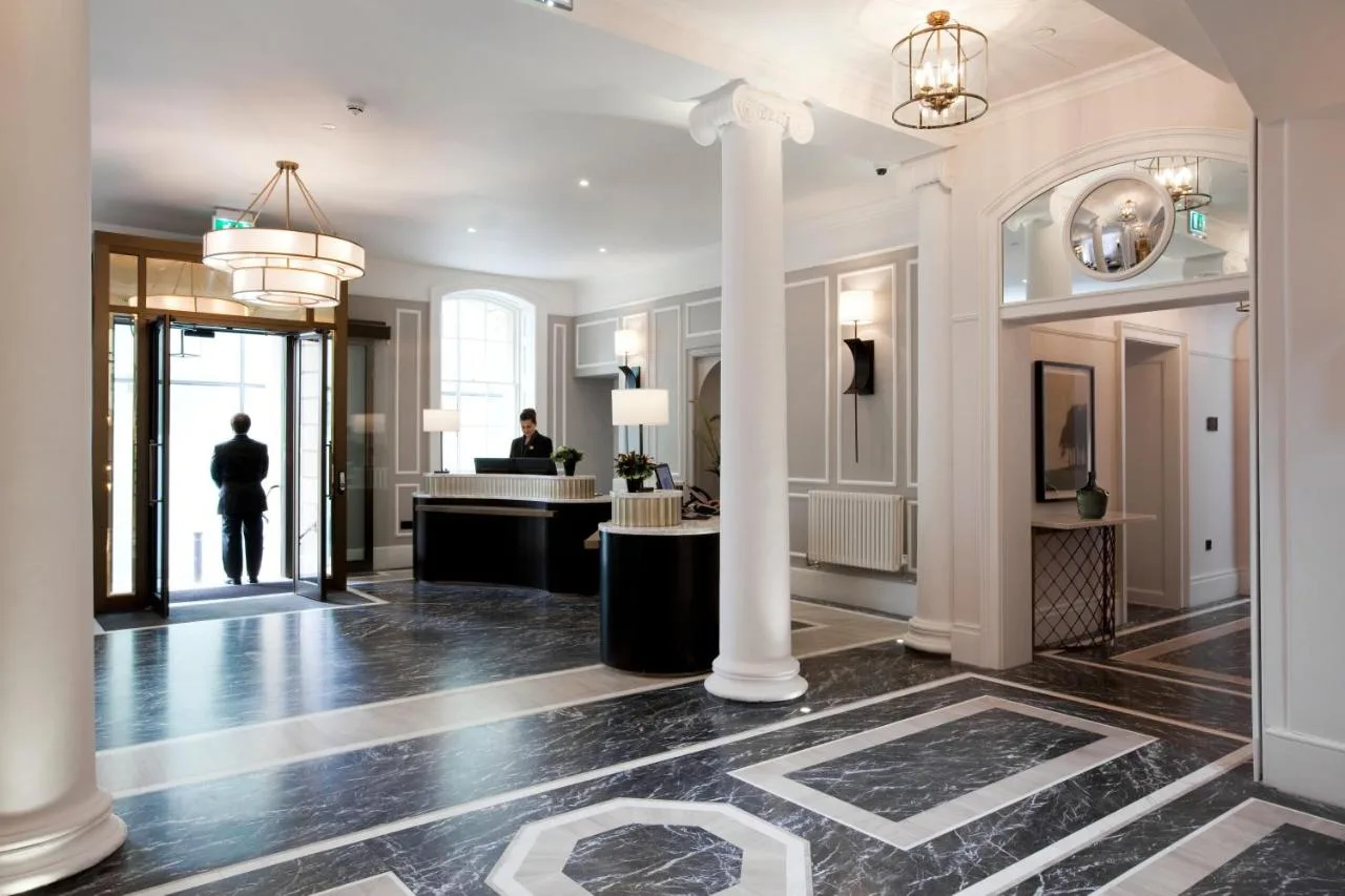 a lobby of a hotel with columns and a reception desk at The Gainsborough Bath Spa in Bath