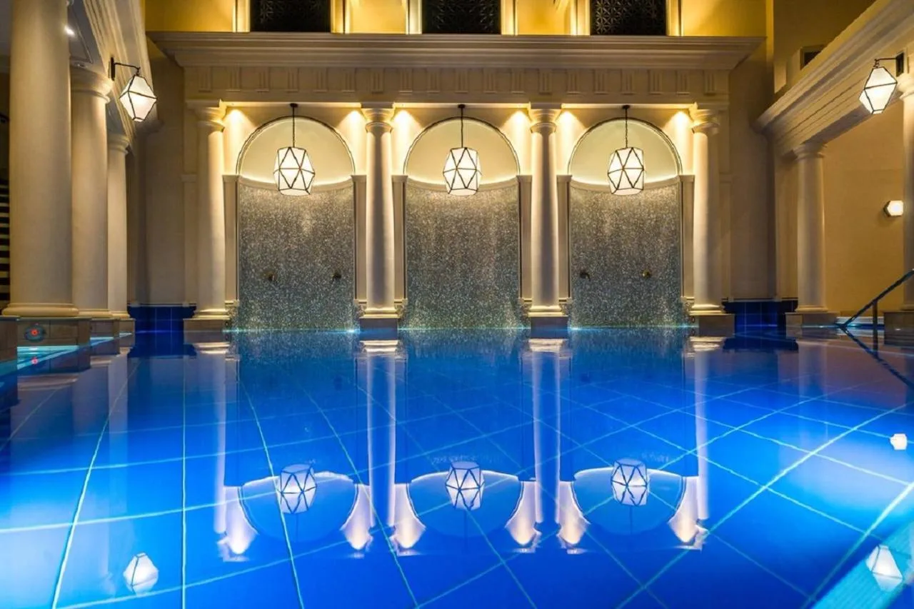 a pool in a hotel lobby with blue water at The Gainsborough Bath Spa in Bath
